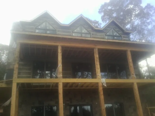 Dormers and porch framing on a large log home under construction — Roof Coating work by our crew in Savonburg