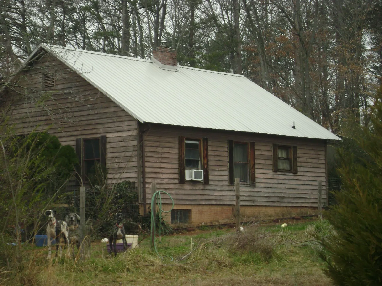 White metal roof on an old wood sided farmhouse, from a Metal Roof Installation job in Savonburg